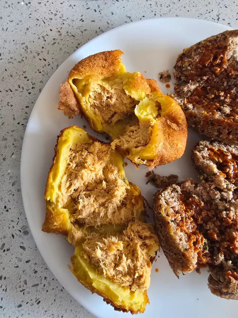 Brazilian savory pastries and meat served on a white plate